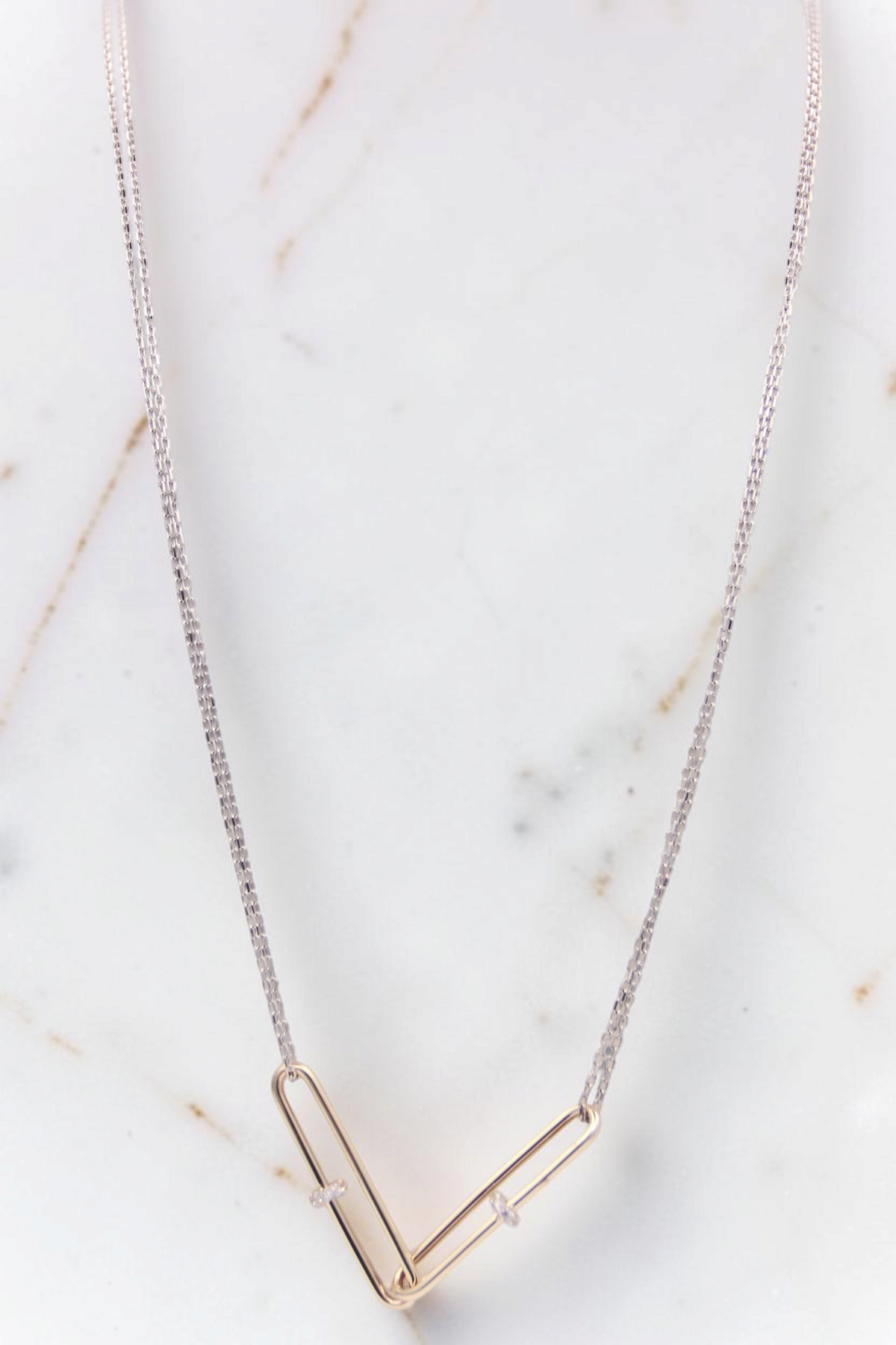 Zafrah 14kt white gold double cable chain necklace with two interlocking yellow gold paperclip-shaped links.