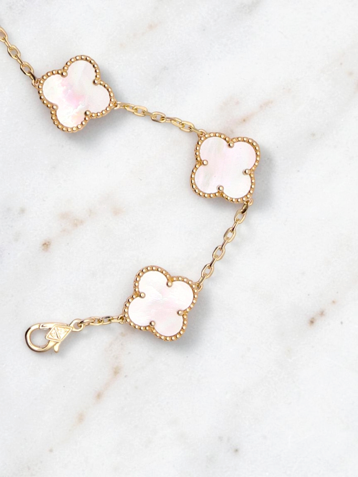 Zafrah 14k yellow gold bracelet featuring five mother of pearl clover motifs on a delicate chain