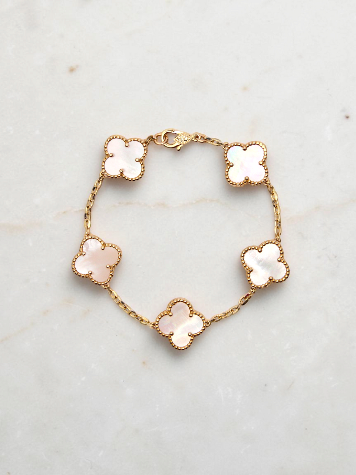 Zafrah 14k yellow gold bracelet featuring five iridescent mother of pearl clover motifs on a delicate chain