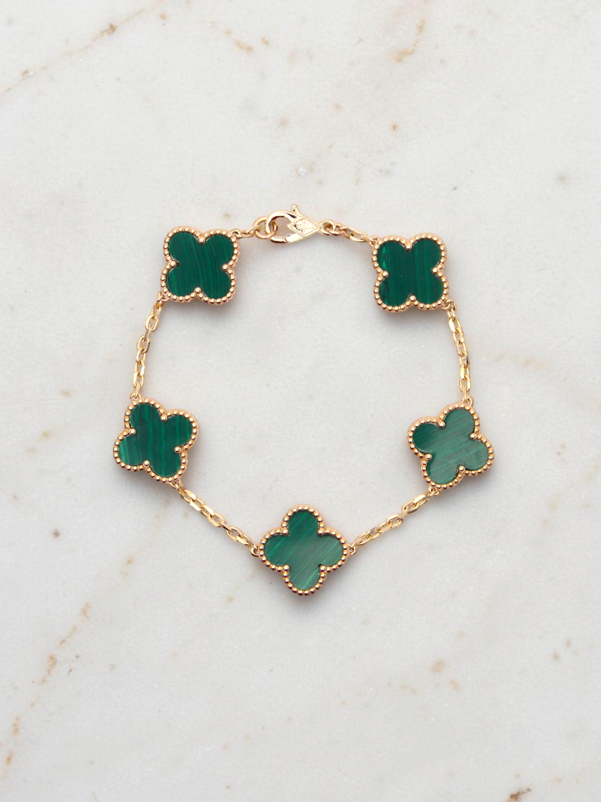 Zafrah 14k yellow gold bracelet featuring five green malachite clover motifs on a delicate chain