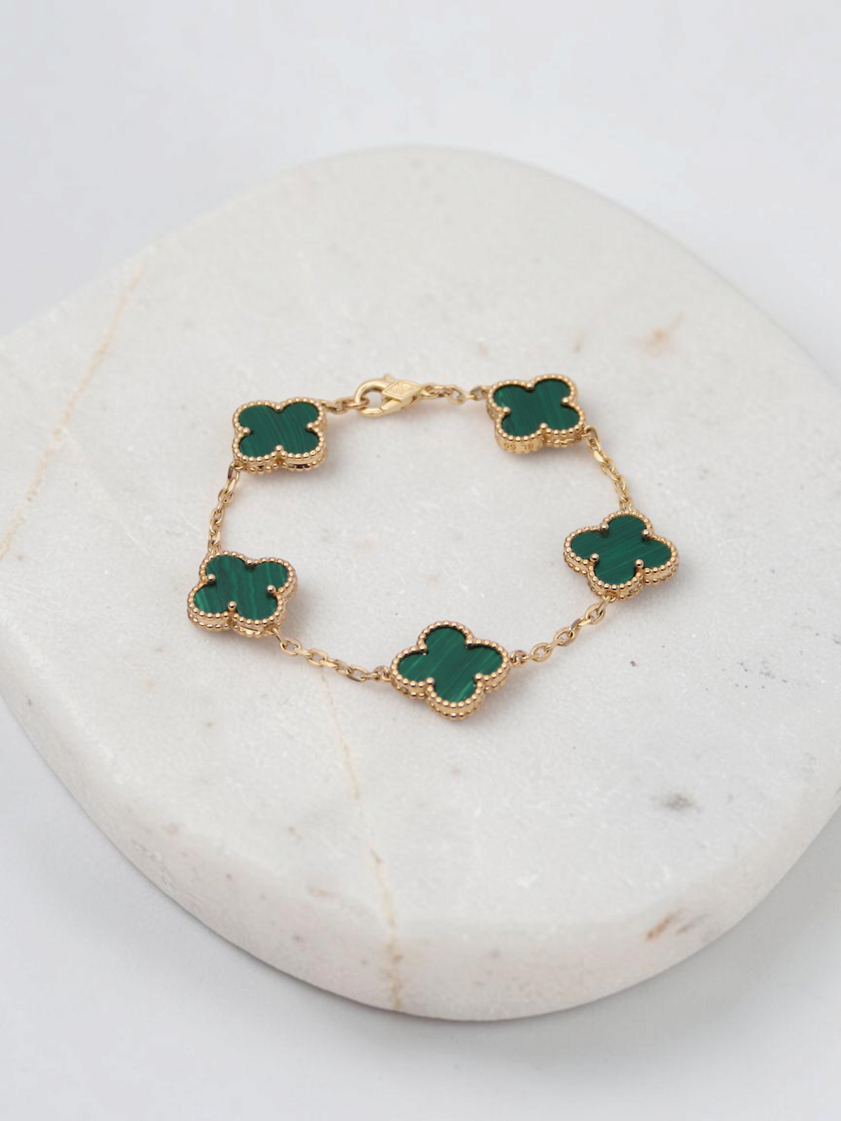 Zafrah 14k yellow gold bracelet featuring five green malachite clover motifs on a delicate chain