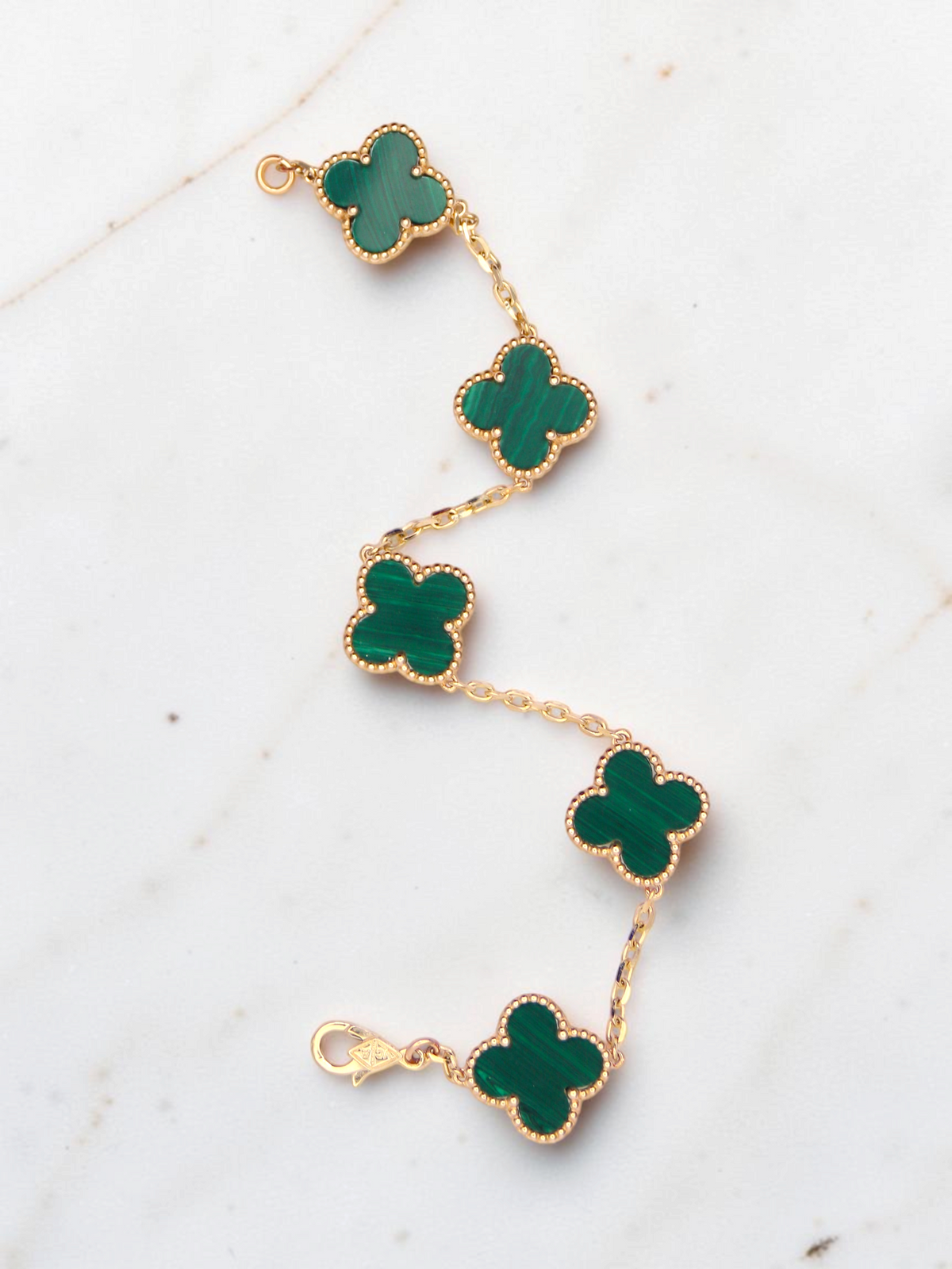 Zafrah 14k yellow gold bracelet featuring five green malachite clover motifs on a delicate chain