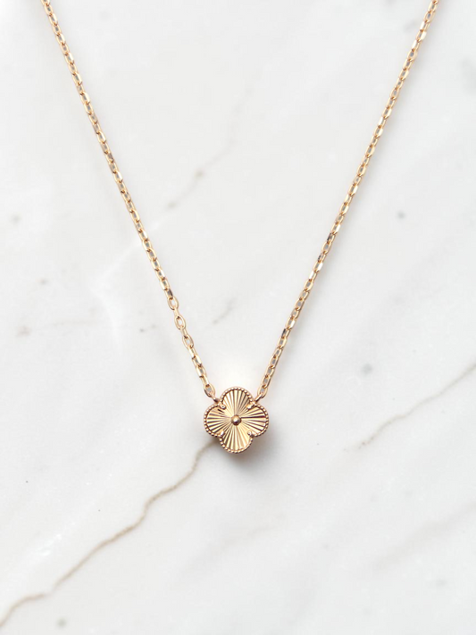 Zafrah 14k yellow gold necklace featuring a single guilloché clover motif pendant on a delicate round link chain.