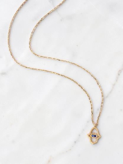 Zafrah 14k yellow gold hamsa eye pendant necklace with two blue stones on a delicate round link chain