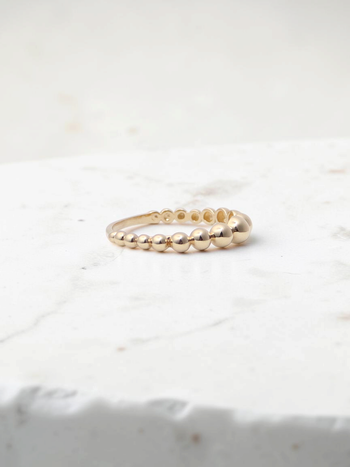 Zafrah 14k yellow gold beaded stacker ring with a delicate polished finish