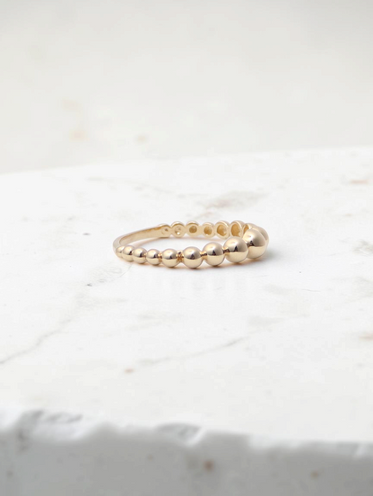 Zafrah 14k yellow gold beaded stacker ring with a delicate polished finish