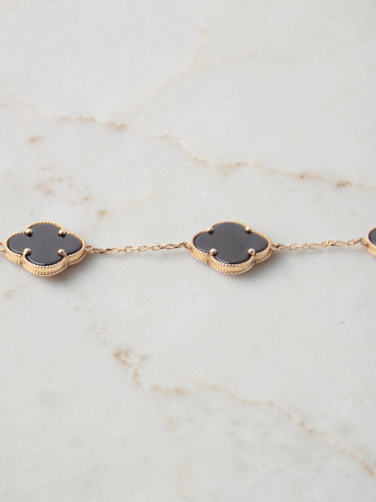 Zafrah gold chain bracelet featuring black onyx clover motifs with delicate beaded edges on a white background