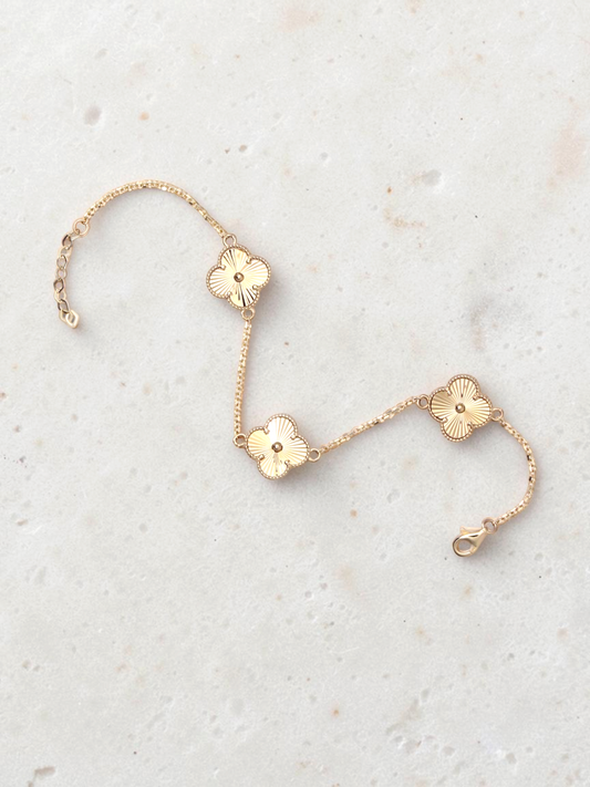 Zafrah 14k yellow gold bracelet featuring three guilloché clover motifs on a delicate round link chain.