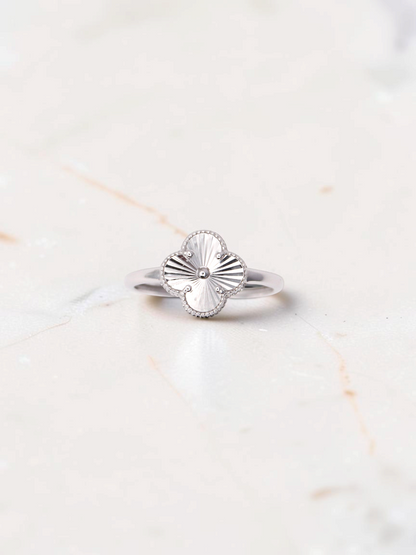 Zafrah 14k white gold clover ring featuring a detailed guilloché pattern on a polished band.
