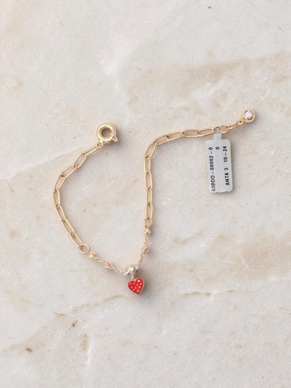 Zafrah 14k tri-color gold paperclip chain bracelet with a red enamel heart charm and adjustable clasp.