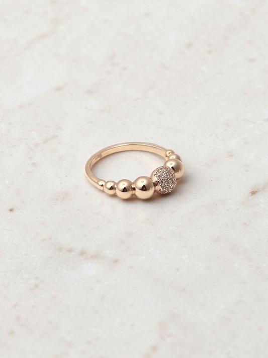Zafrah Pavé Bubble Stacker Ring in 14k yellow gold with sparkling CZ stones on a neutral textured surface