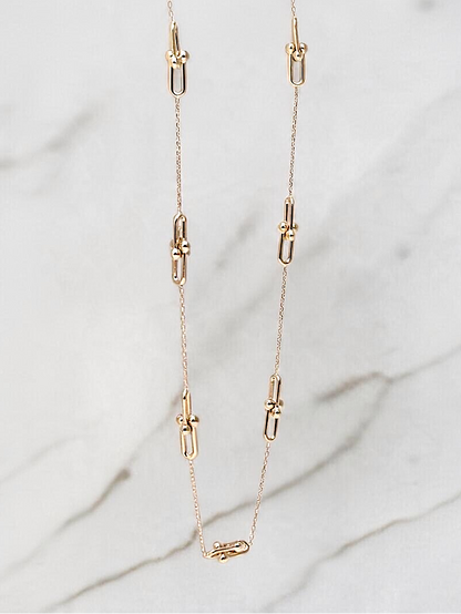 Zafrah 14k yellow gold beaded paperclip chain necklace with adjustable length on a marble background