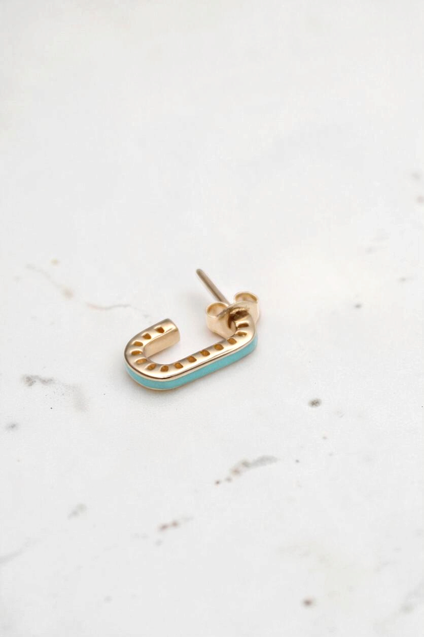 Zafrah dainty 14k solid gold rectangular stud earring with turquoise enamel inlay on a white textured background