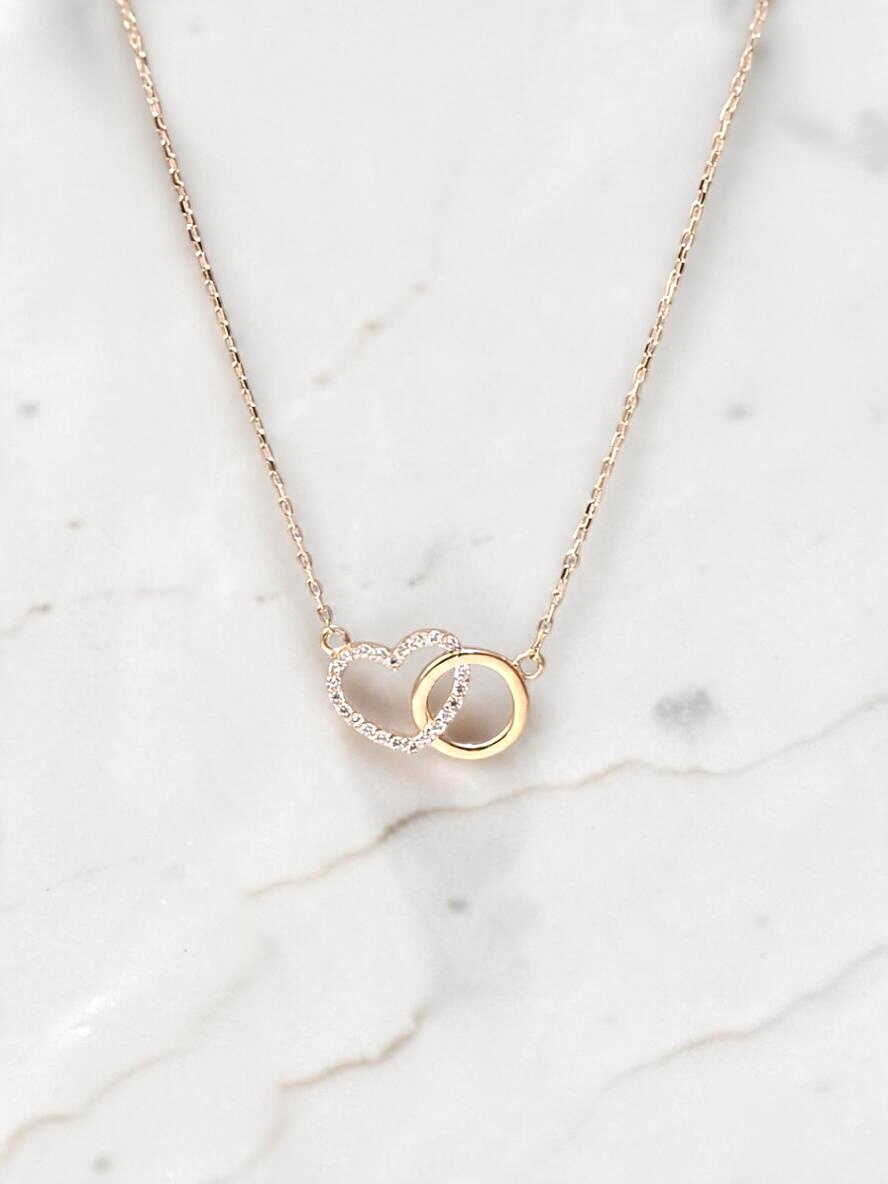 Zafrah interlocking heart necklace in 10k yellow gold with sparkling CZ stones on a delicate adjustable chain.