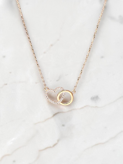 Zafrah interlocking heart necklace in 10k yellow gold with sparkling CZ stones on a delicate adjustable chain.