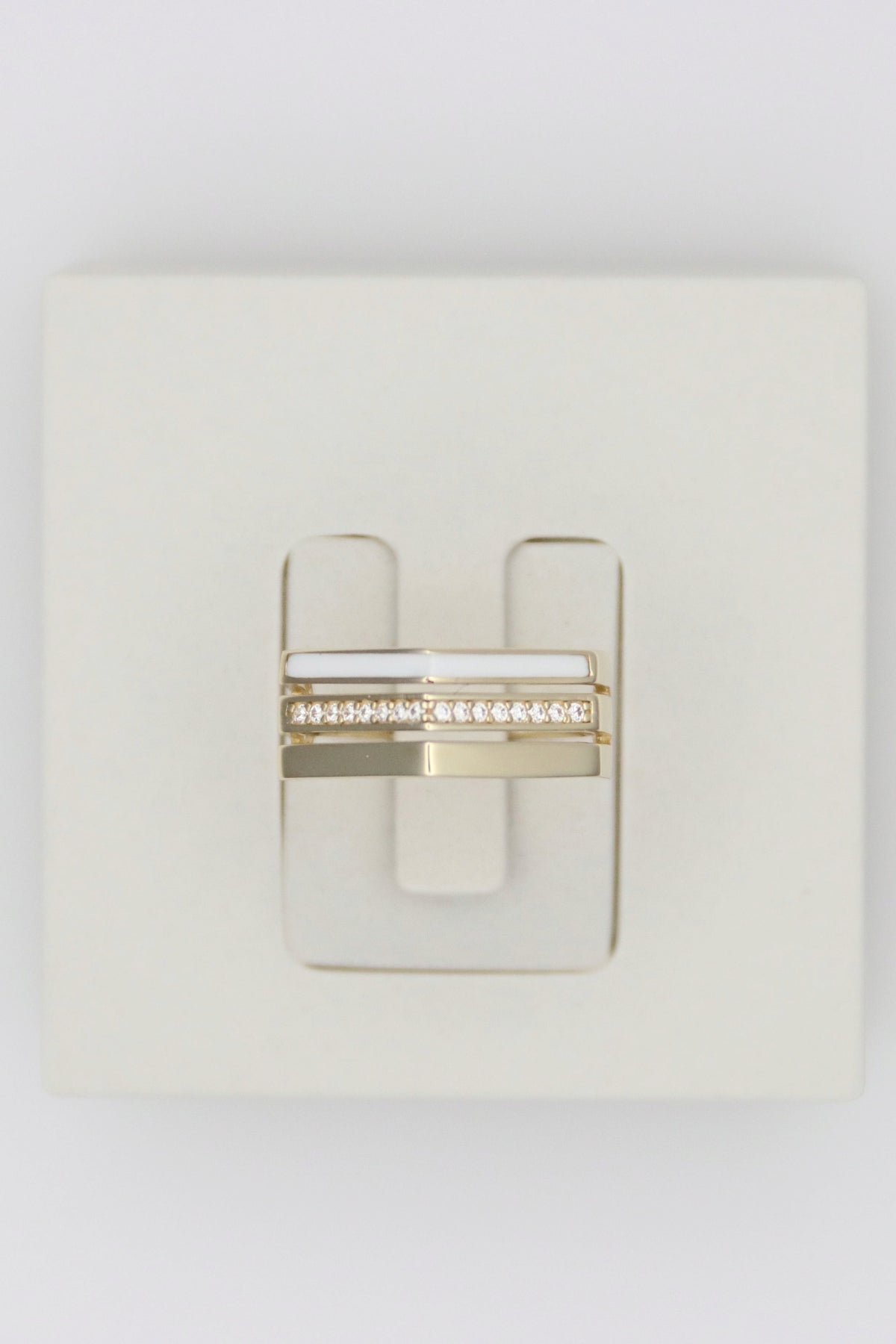 Zafrah 14k solid gold triple line ring featuring a white enamel band and a row of sparkling diamonds.