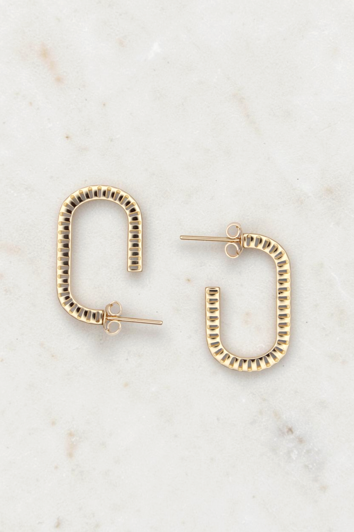 Zafrah 14k solid gold rectangular stud earrings with a unique curved design and textured edges on a white background.