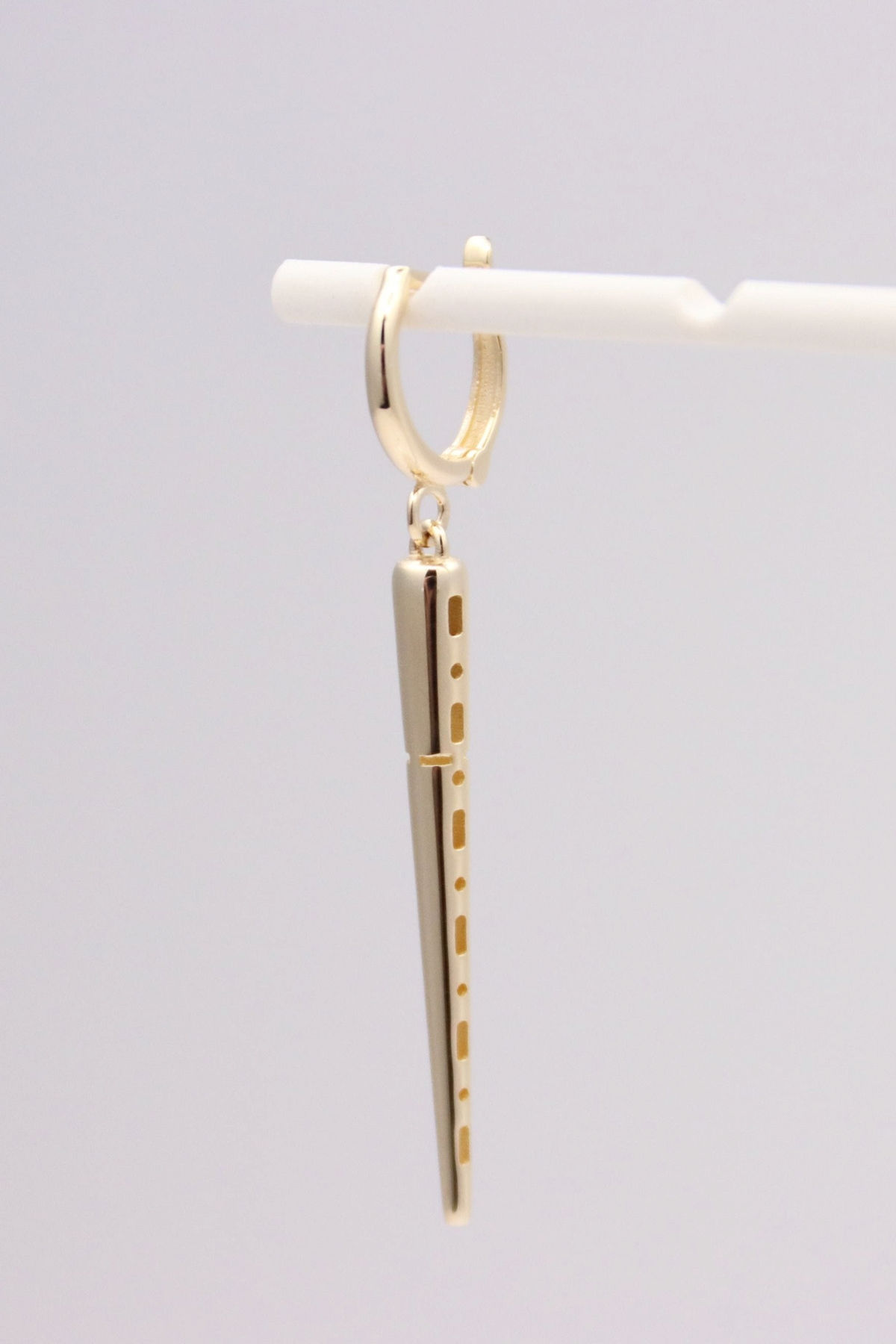 Zafrah 14k solid gold drop hoop earrings featuring a polished spiked charm on a white marble background.