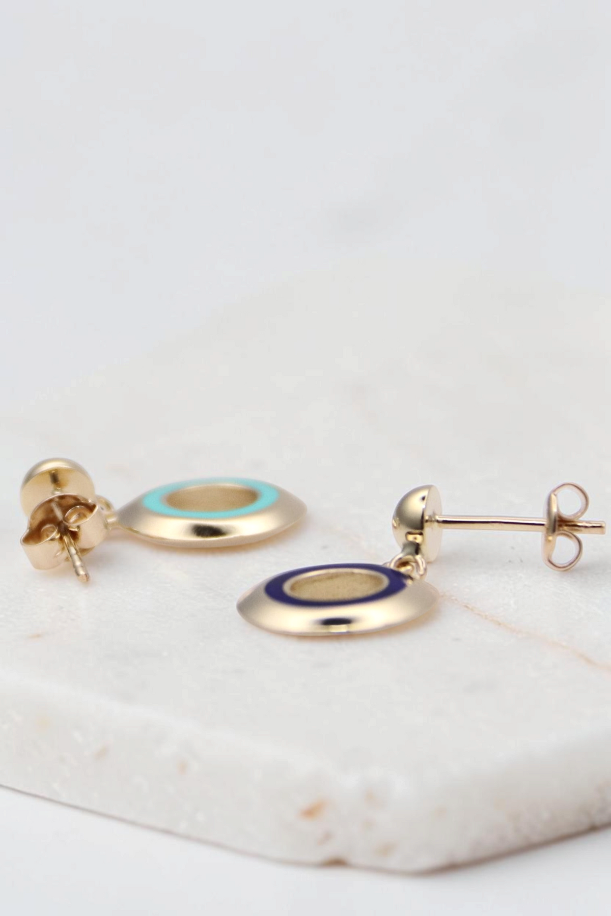 Zafrah 14k gold circle earrings featuring turquoise and blue enamel inlay on a white background
