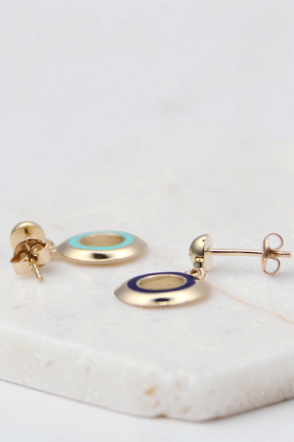 Zafrah 14k gold circle earrings featuring turquoise and blue enamel inlay on a white background
