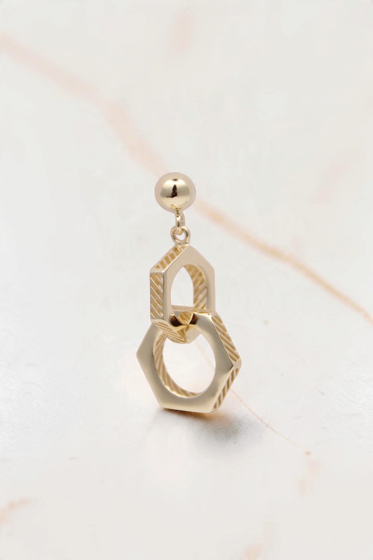 Zafrah 14k solid gold double hexagon drop earrings with an industrial-inspired textured design.