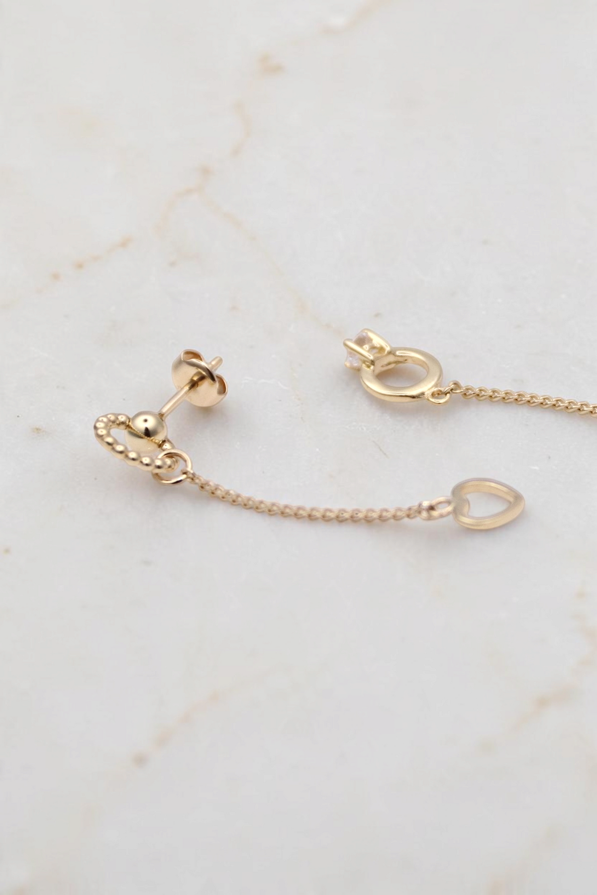 Zafrah 14k solid gold drop earrings featuring a bead ring, open heart charm, and a tiny ring with a round CZ stone.
