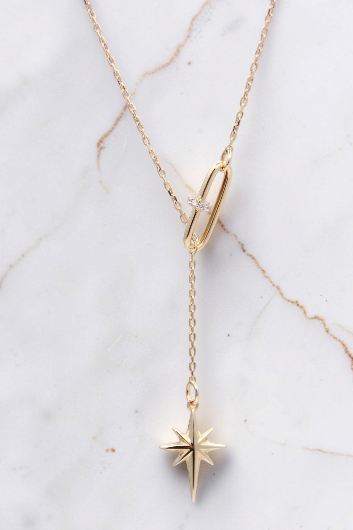 Zafrah 14k solid gold lariat necklace featuring a paper clip link with diamonds and a dangling north star pendant.