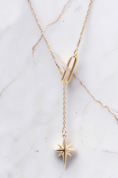 Zafrah 14k solid gold lariat necklace featuring a paper clip link with diamonds and a dangling north star pendant.
