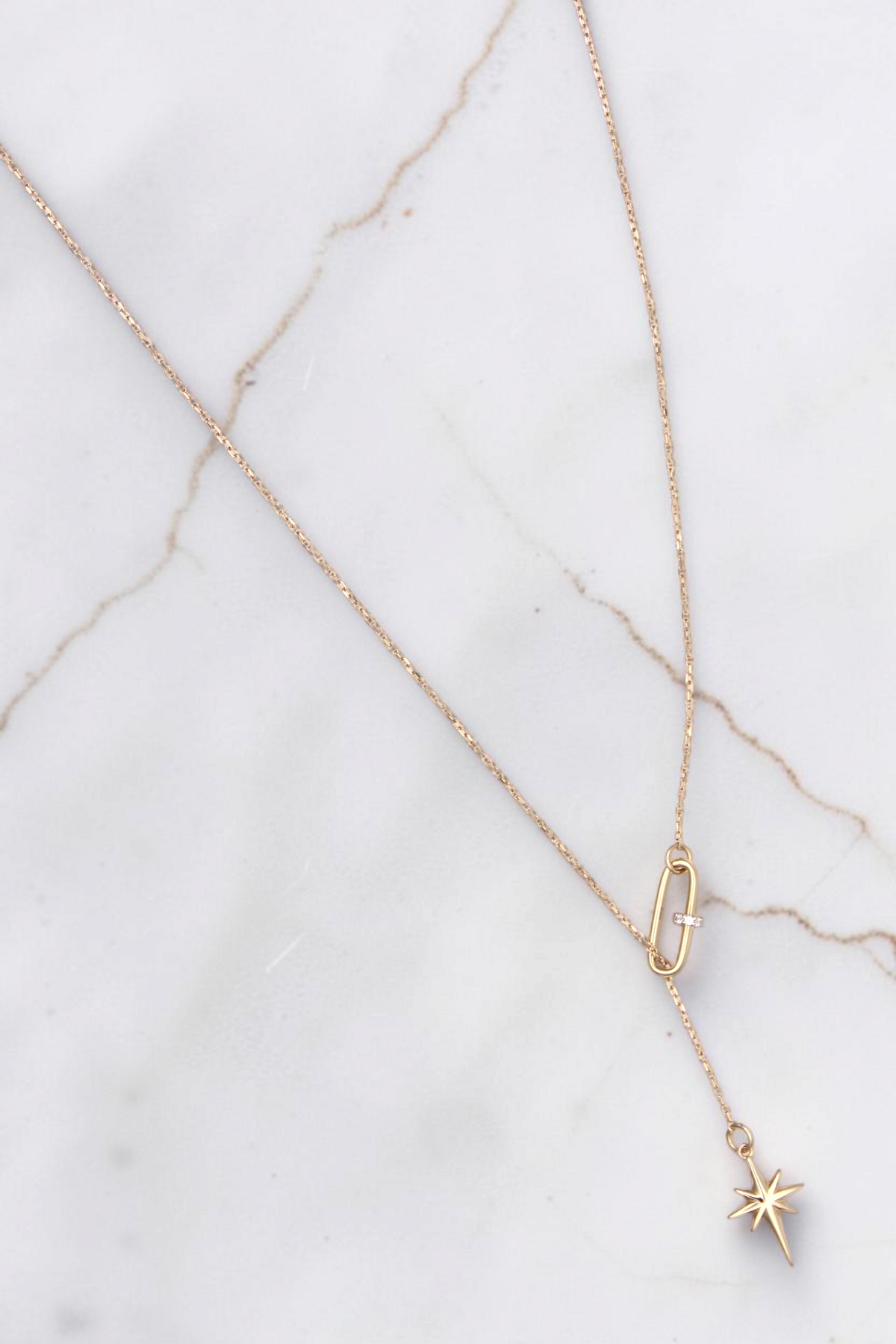 Zafrah 14k solid gold necklace featuring a paper clip link and a delicate north star pendant on an 18-inch chain.