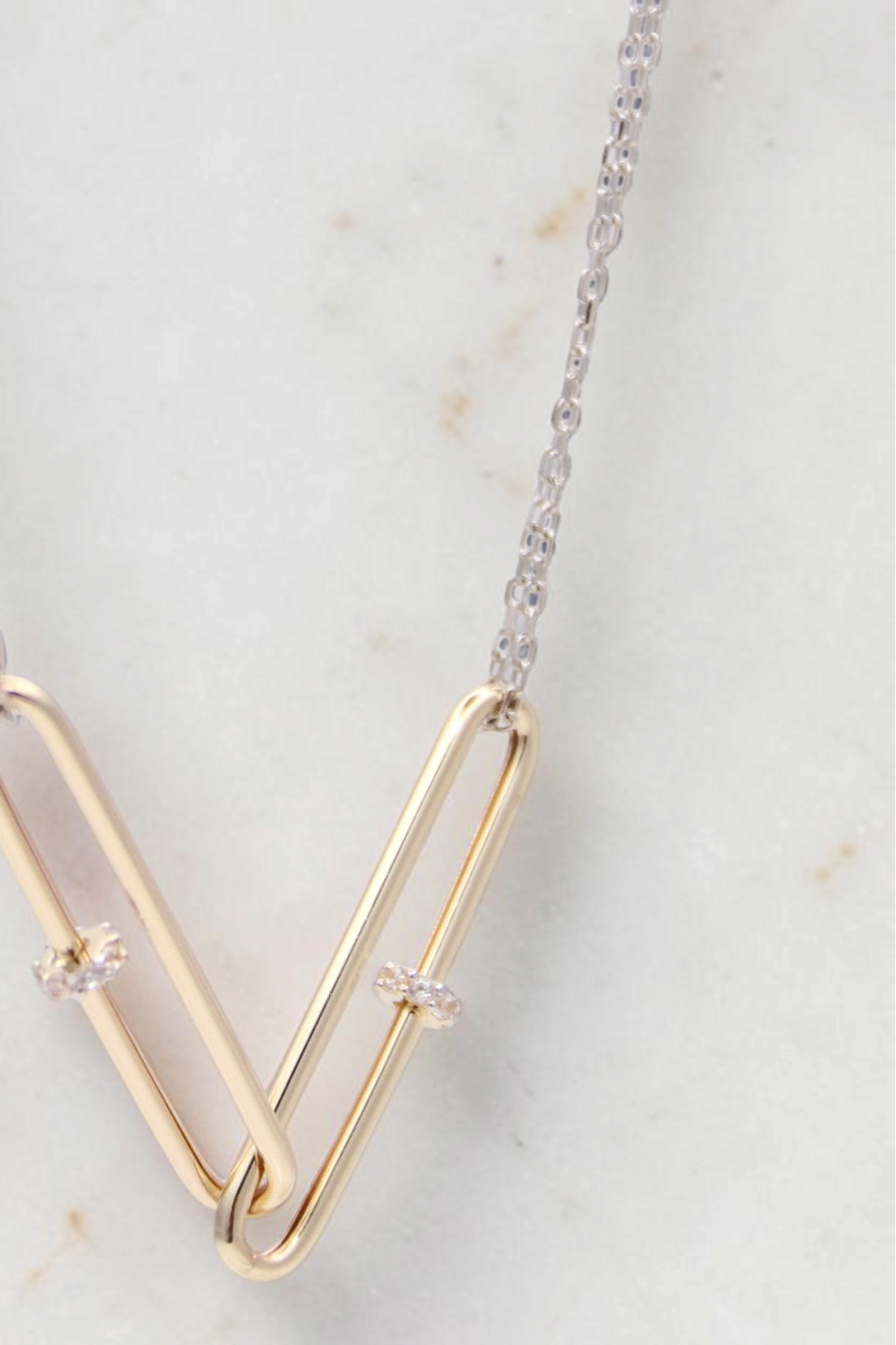 Zafrah 14kt gold double paperclip necklace with white gold cable chain and two linked paperclip-shaped pendants.