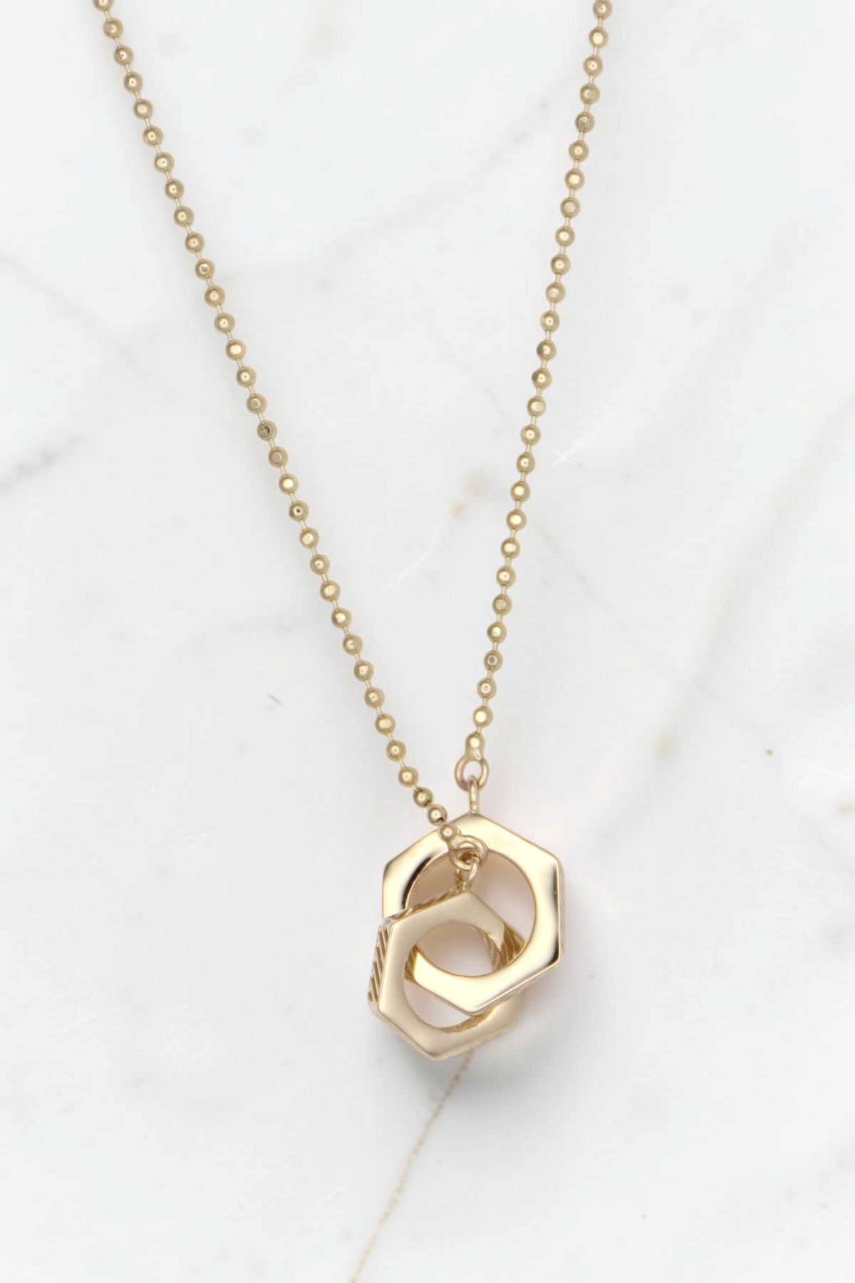 Zafrah 14k solid gold Hexagon Duo bead necklace featuring two interlocking geometric pendants on an 18-inch chain.