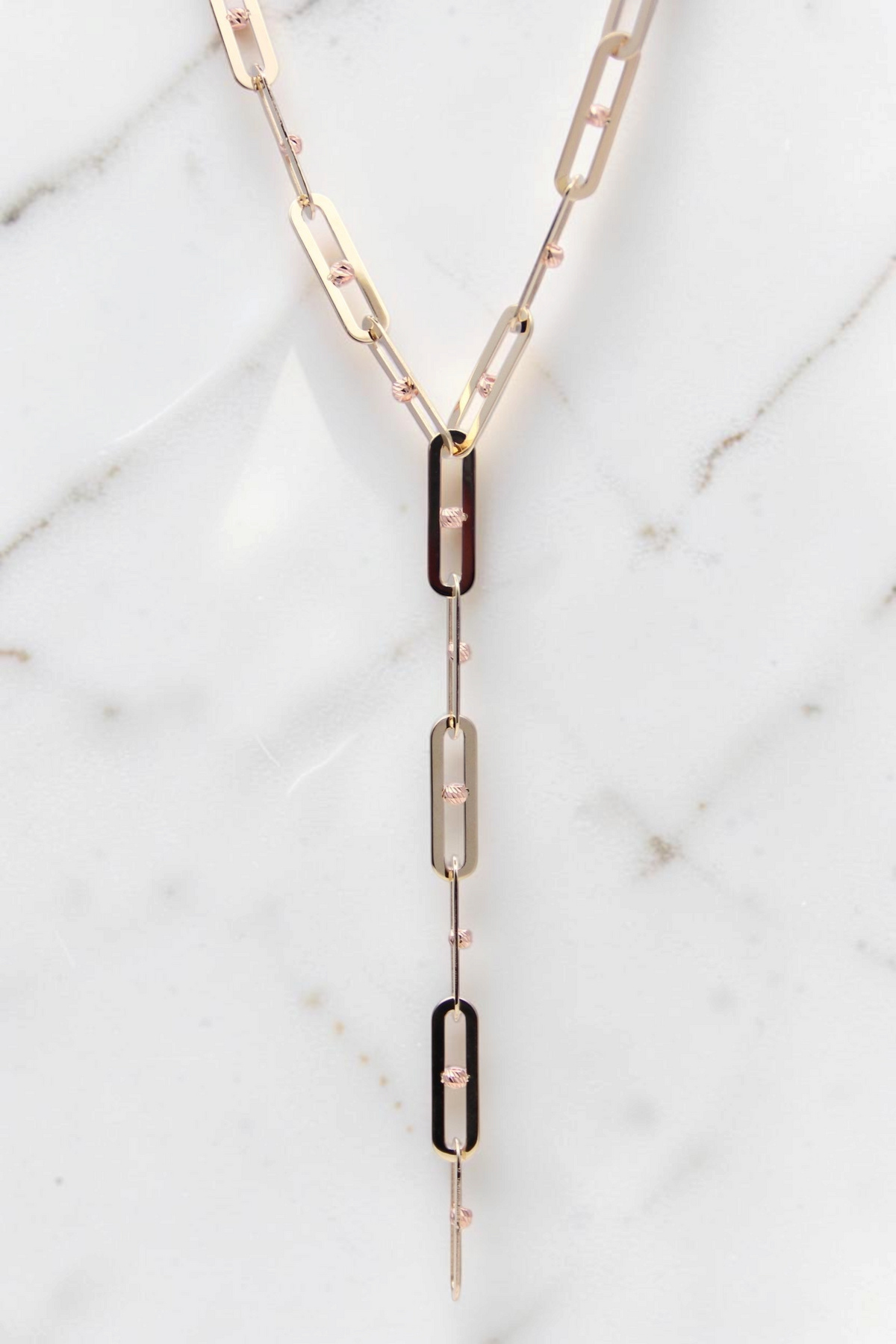 Zafrah 14k solid gold Y-shaped necklace featuring elongated paperclip links with delicate textured gold bead accents.