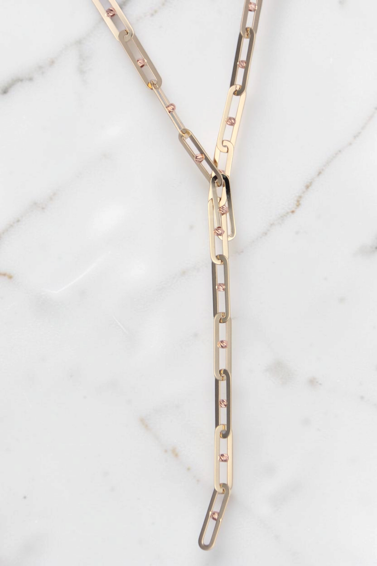 Zafrah 14k solid gold Y-shaped necklace featuring polished paperclip links with small textured bead accents.