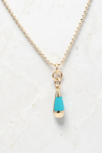 Zafrah 14k gold beaded chain necklace featuring a turquoise and white teardrop pendant on a light background.