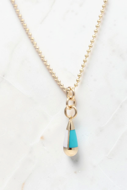 Zafrah 14k gold beaded chain necklace featuring a turquoise and white teardrop pendant on a light background