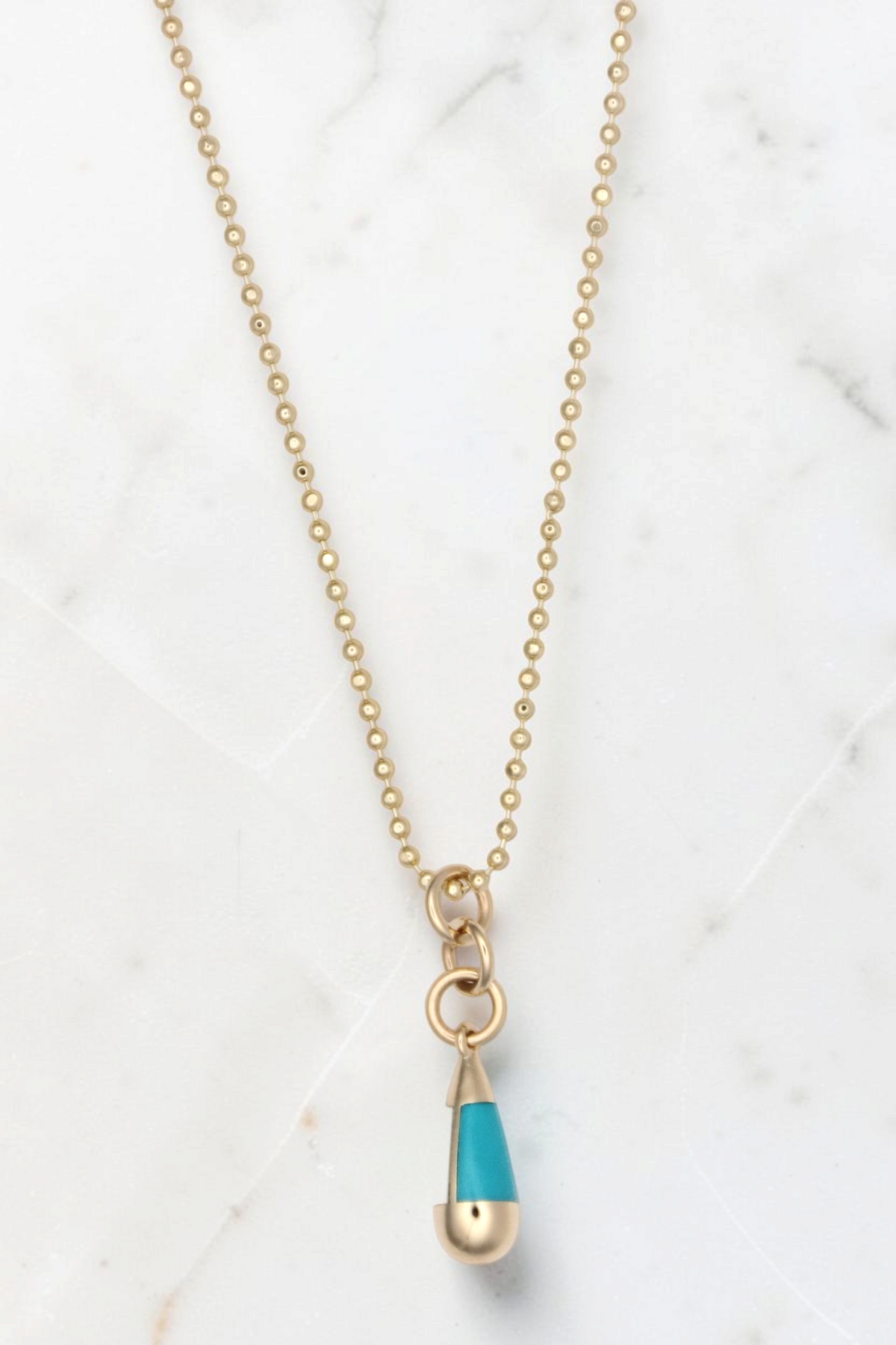 Zafrah 14k gold beaded chain necklace featuring a turquoise and gold drop pendant on a white background
