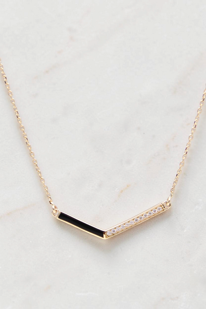 Zafrah 14k gold curb chain necklace featuring a V-shaped pendant with black enamel and sparkling diamond accents