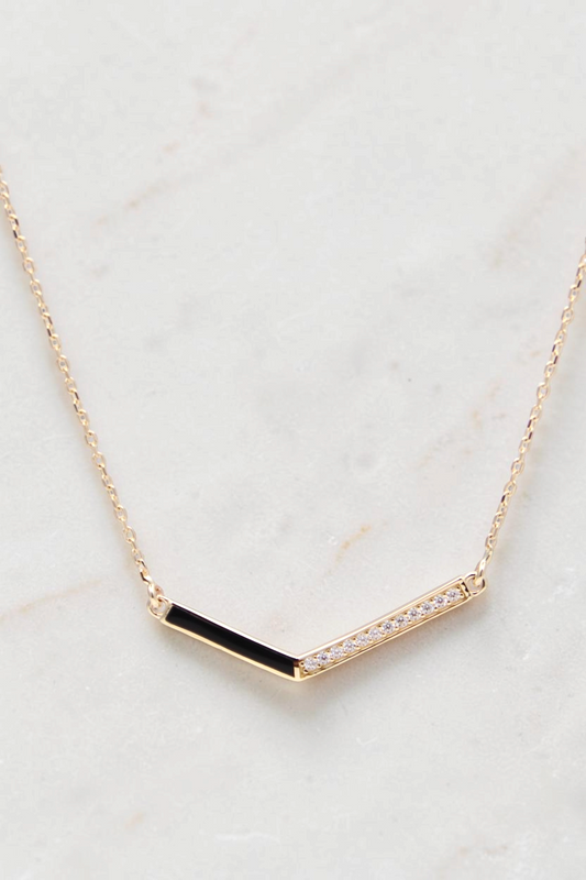 Zafrah 14k gold curb chain necklace featuring a V-shaped pendant with black enamel and sparkling diamond accents