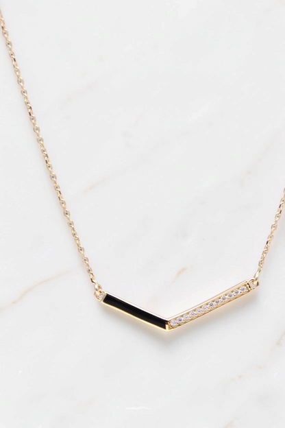 Zafrah 14k gold V-shaped pendant necklace featuring a black enamel side and a row of sparkling pavé diamonds.