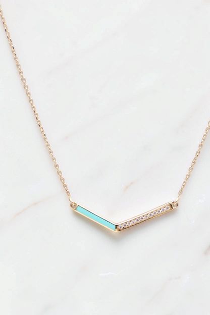 Zafrah 14k gold V-shaped pendant necklace featuring a turquoise enamel inlay and a row of sparkling diamonds.