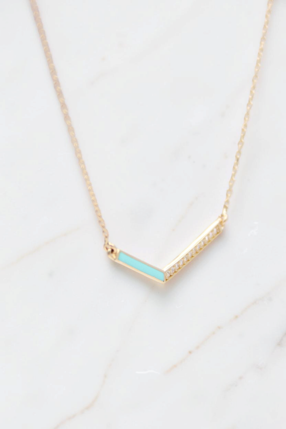Zafrah 14k gold V-shaped pendant necklace featuring a turquoise enamel inlay and delicate diamond accents