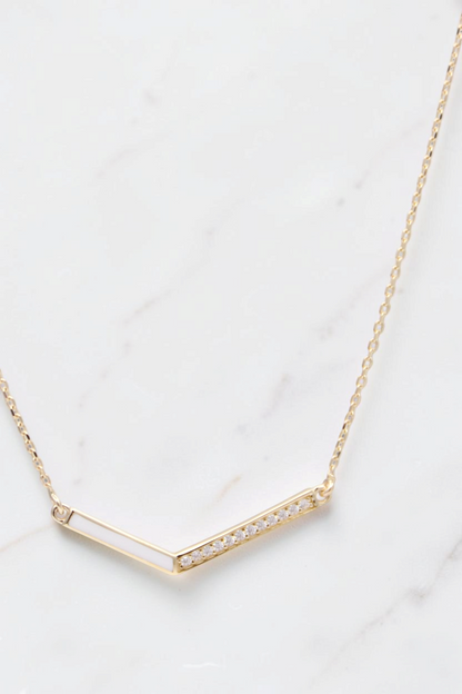 Zafrah 14k solid gold V-shaped pendant necklace on a thin curb chain with delicate stone accents