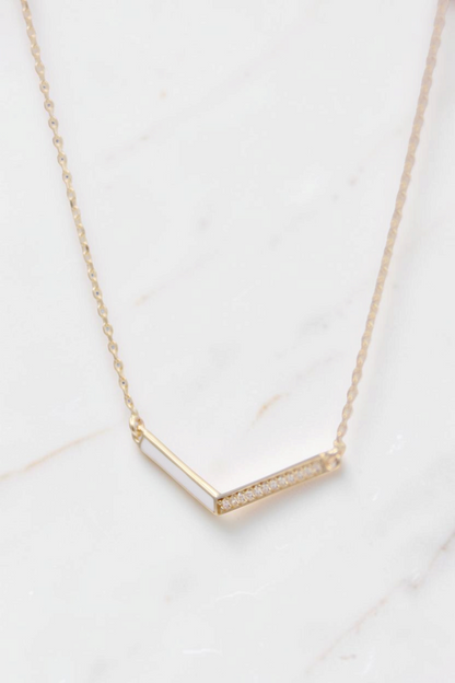 Zafrah 14k solid gold necklace featuring a delicate V-shaped pendant with small inset diamonds on a thin curb chain.