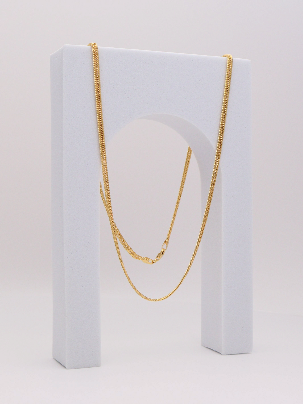 Zafrah 14k yellow gold 2.75mm snake chain necklace, 21.5 inches long, displayed on a white arch stand.