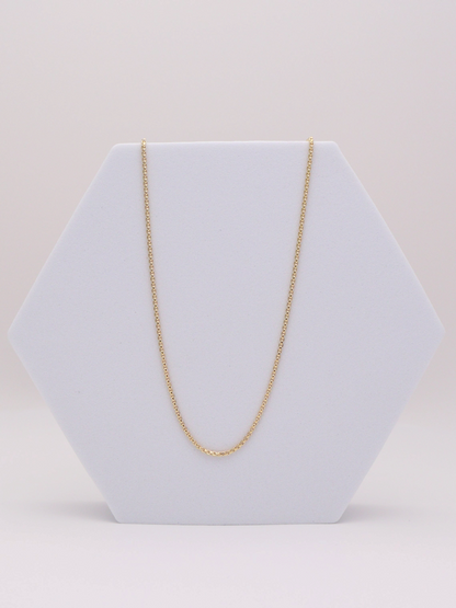 Zafrah 14k yellow gold 1mm square rolo chain necklace measuring 21.5 inches in length on a white hexagonal display.