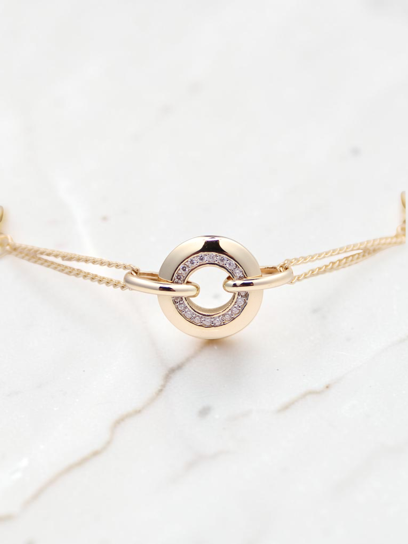 Zafrah 14k solid gold curb chain bracelet featuring a central round link with sparkling CZ stones on a white display