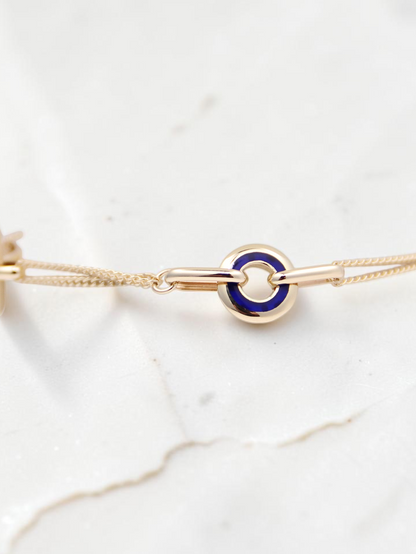 Zafrah 14k solid gold curb chain bracelet featuring a round link with a vibrant blue CZ stone inlay.