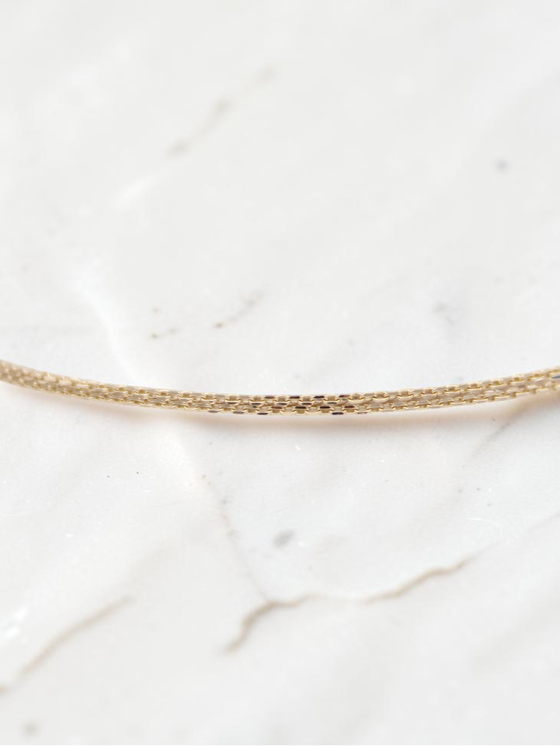 Zafrah 14k solid gold double cable bracelet featuring delicate rectangle and oval links, 7 inches in length.