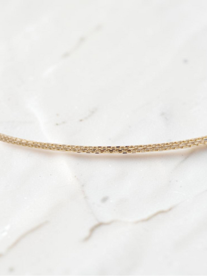 Zafrah 14k solid gold double cable bracelet featuring delicate rectangle and oval links, 7 inches in length.
