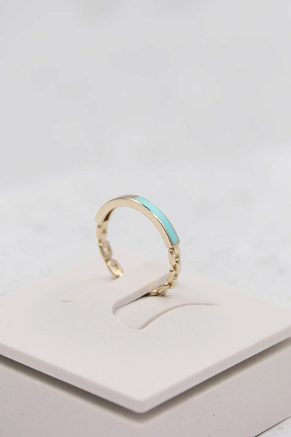 Zafrah 14k solid gold chain link ring featuring a delicate turquoise enamel inlay on a white display stand
